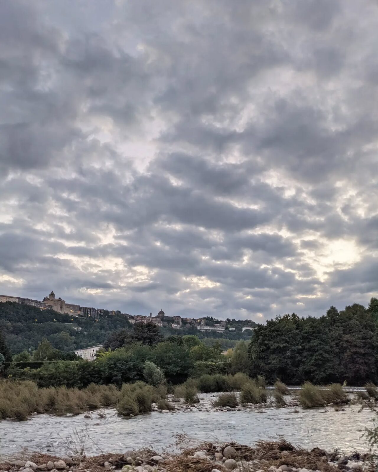 Depuis la rivière de l'Ardèche du sur les Aubenas en hauteur avec un ciel gris de nuages